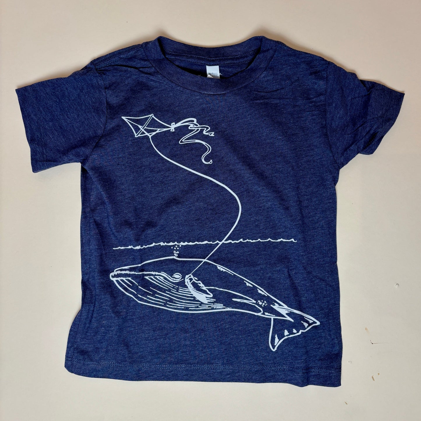 Original whale & kite artwork by Animal Instincts Apparel
Soft, durable kids’ tee in heather navy
Printed/embroidered in-house at our Northampton, MA shop