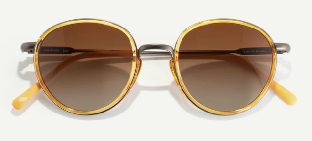 Round sunglasses with gold frames and brown lenses on a white background