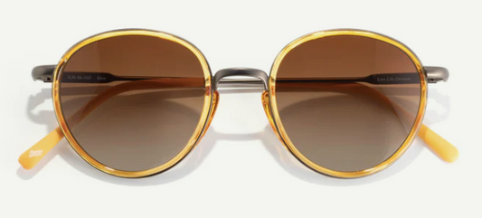 Round sunglasses with gold frames and brown lenses on a white background