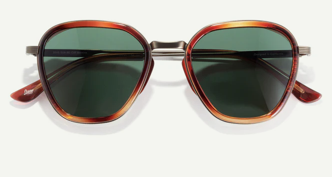 Sunglasses with tortoiseshell frame and green lenses on a white background