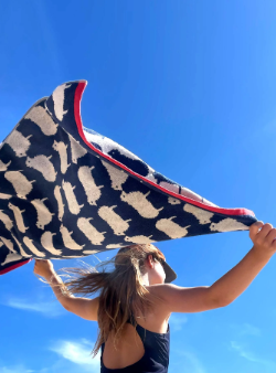 woman holding blue sheep towel blowing in the wind