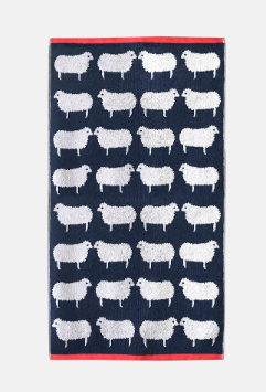 kissing sheep patterned towel laid out, dark blue with white sheep and coral trim