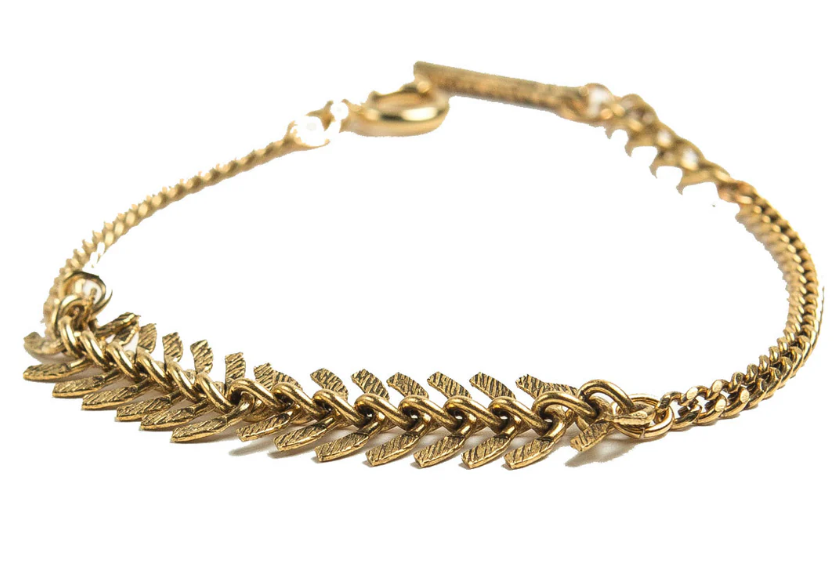 Gold bracelet with leaf-like designs on a white background