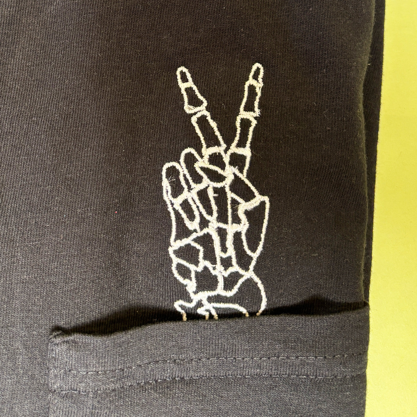 Unisex Embroidered Skeleton Peace Hand Pocket Tee