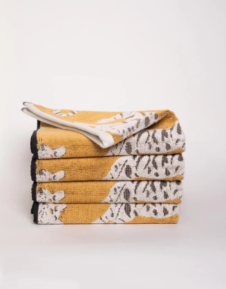 pile of yellow towels with white tigers jumping pattern with black trim