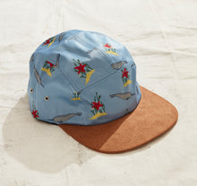 A light blue hat with hand-drawn designs of Narwhals and starfish. The brim of the hat is brown suede.